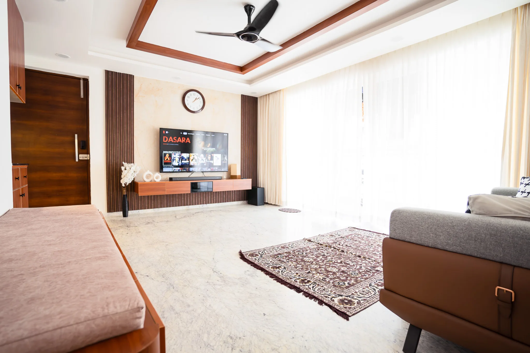 Living room with timber-framed ceiling, TV unit and patterned rug