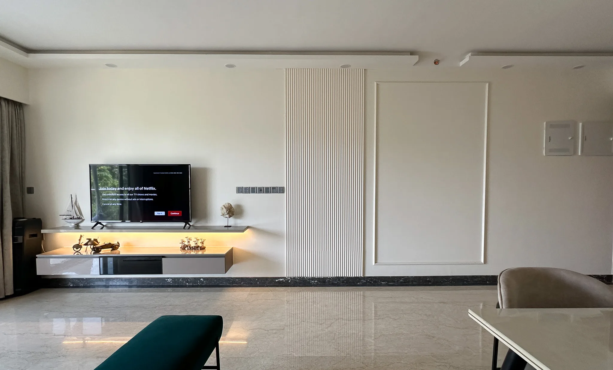 Minimal TV wall with floating lit console and fluted panel